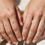 Elegant small hand tattoos on fingers
