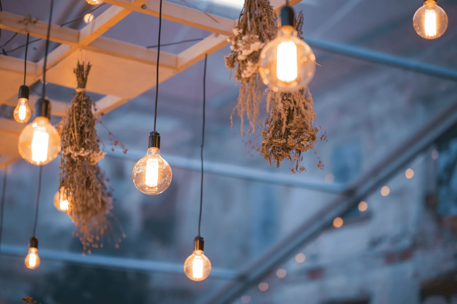 Rustic lantern and antler chandelier lighting over a wooden dining table