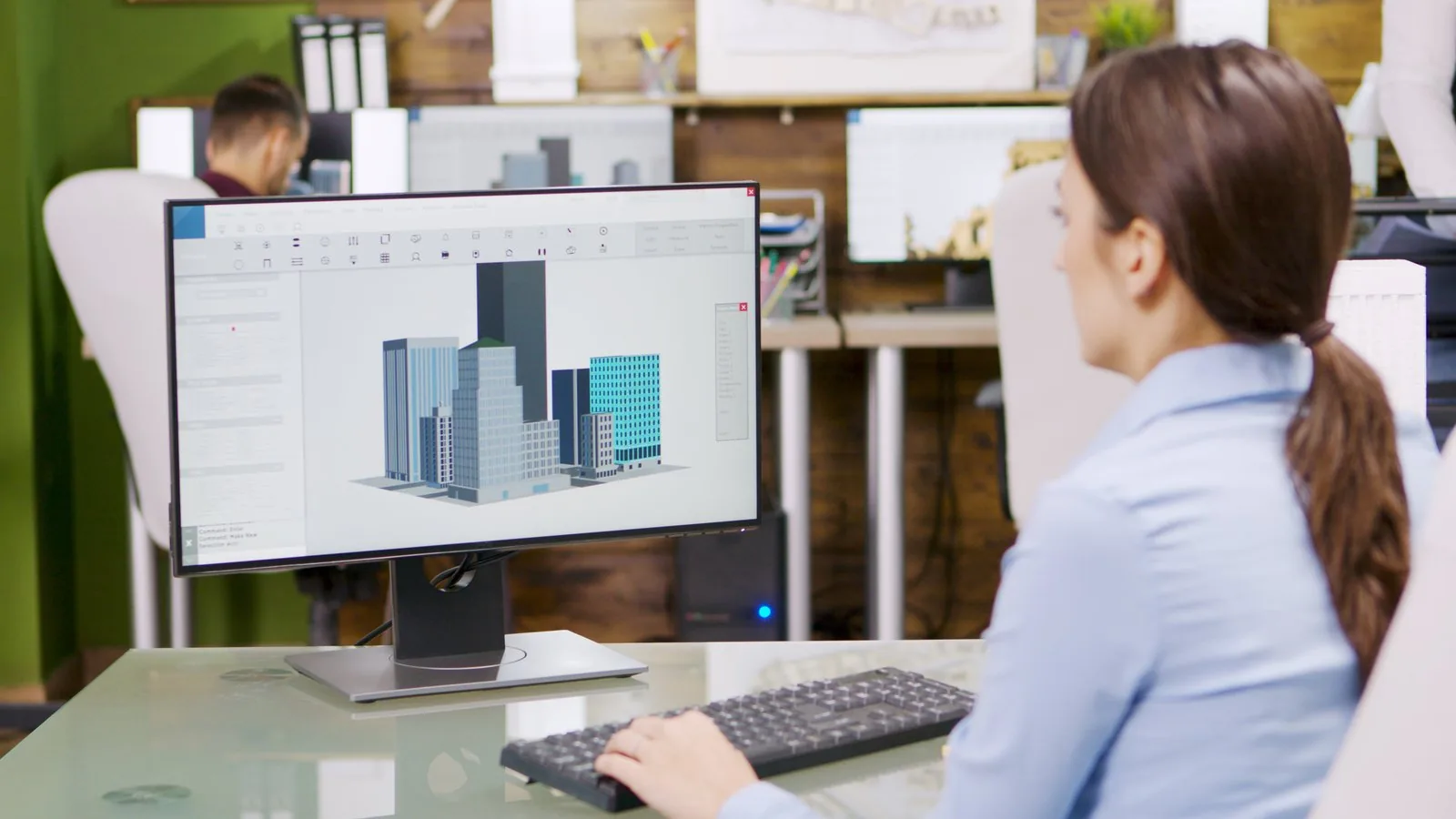 Female architect creating a 3D building model on her computer