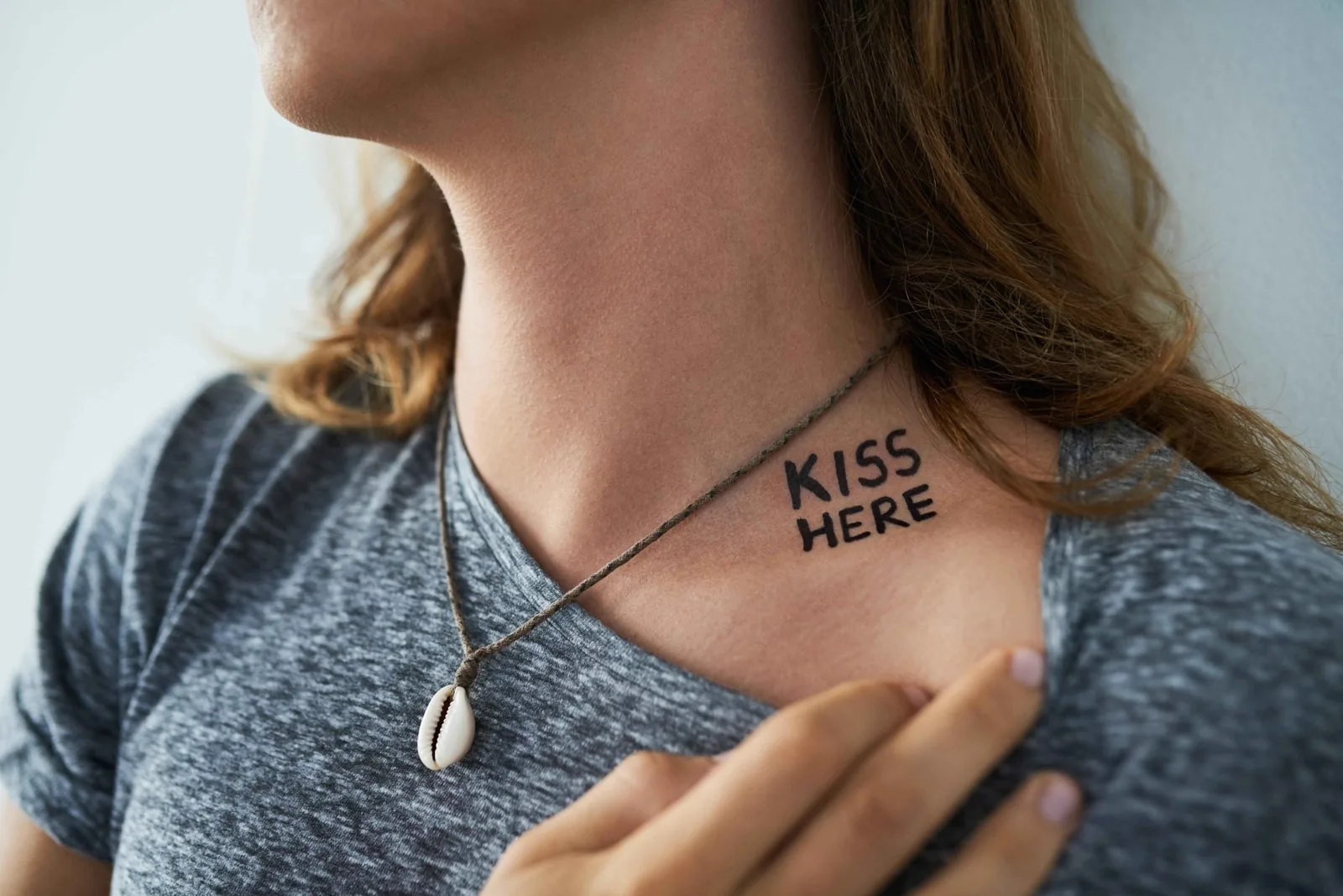 Man showing name tattoo on side of neck