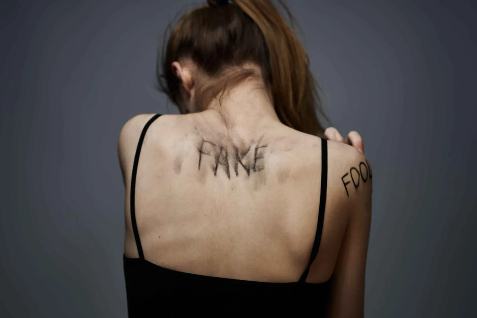 Woman with lettering tattoo on neck