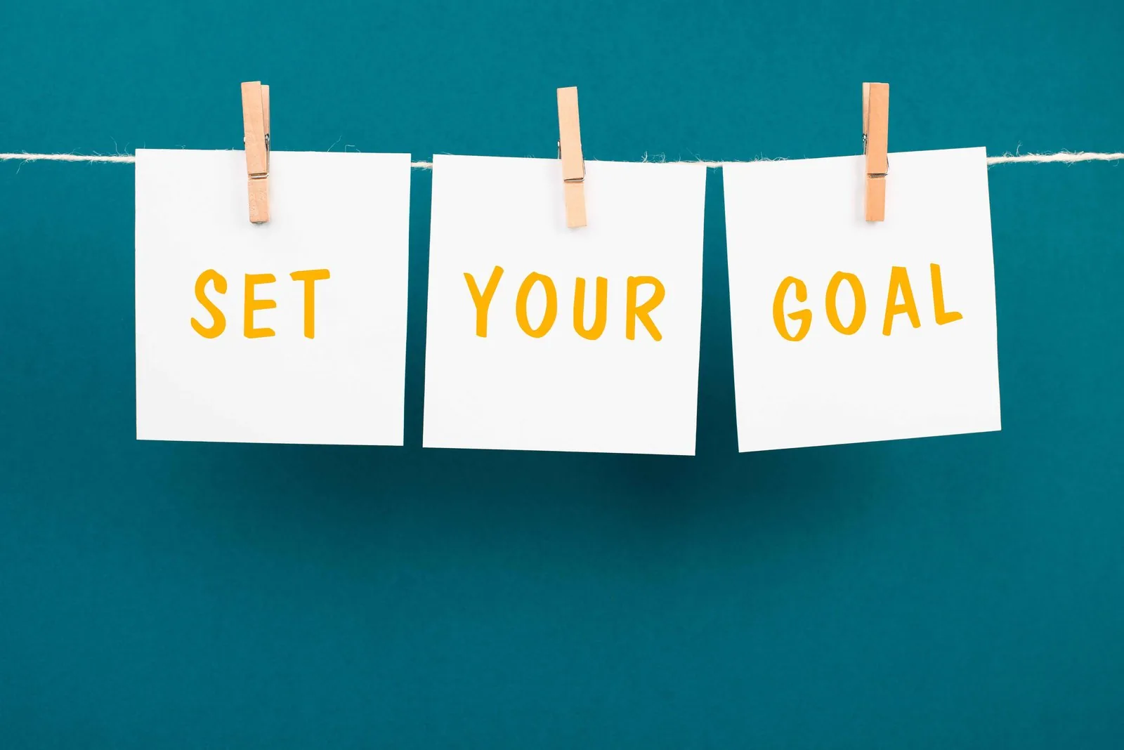 Wooden blocks spelling out a goal-setting reminder on a desk