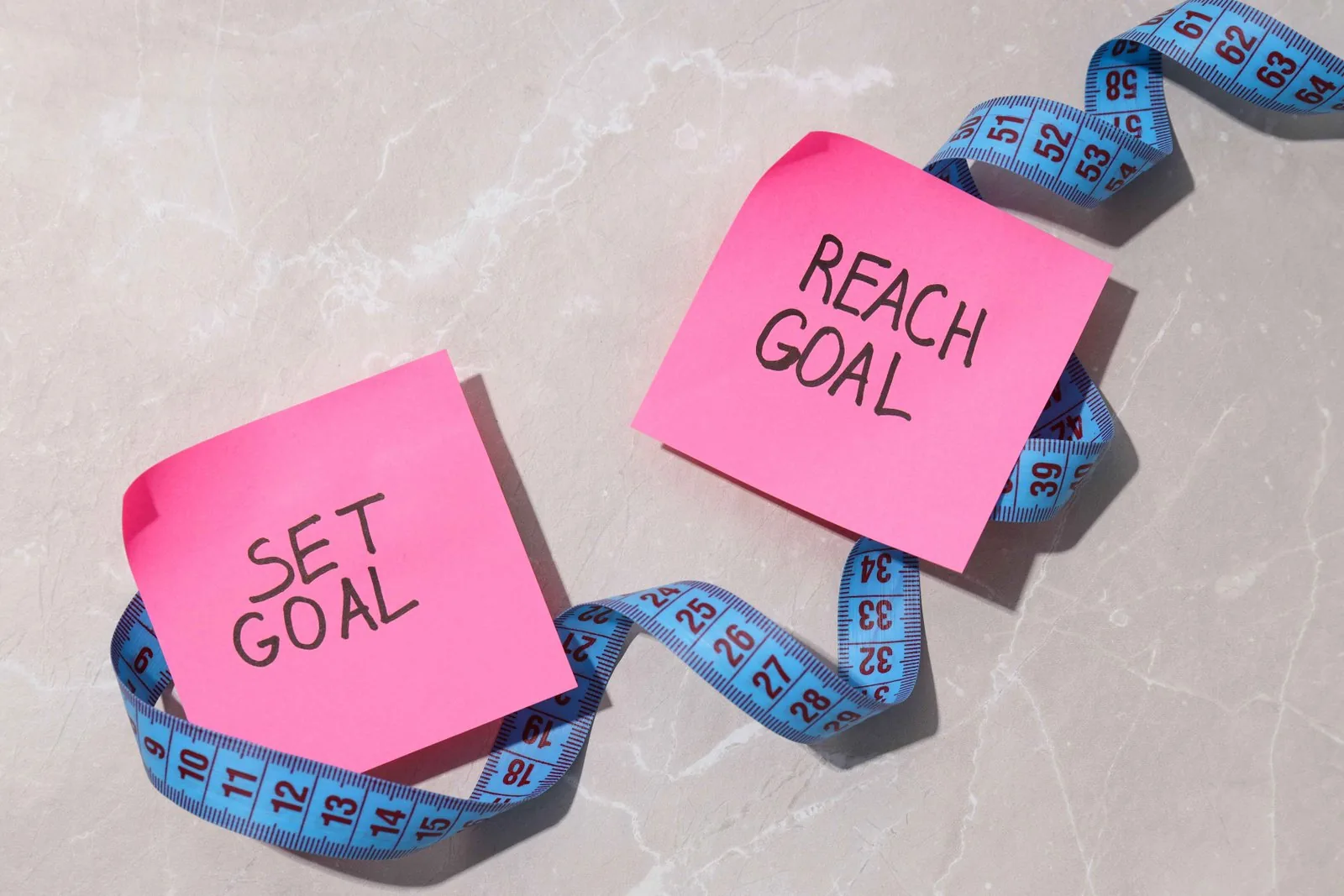 Goal planning written on paper sheets with a measuring tape