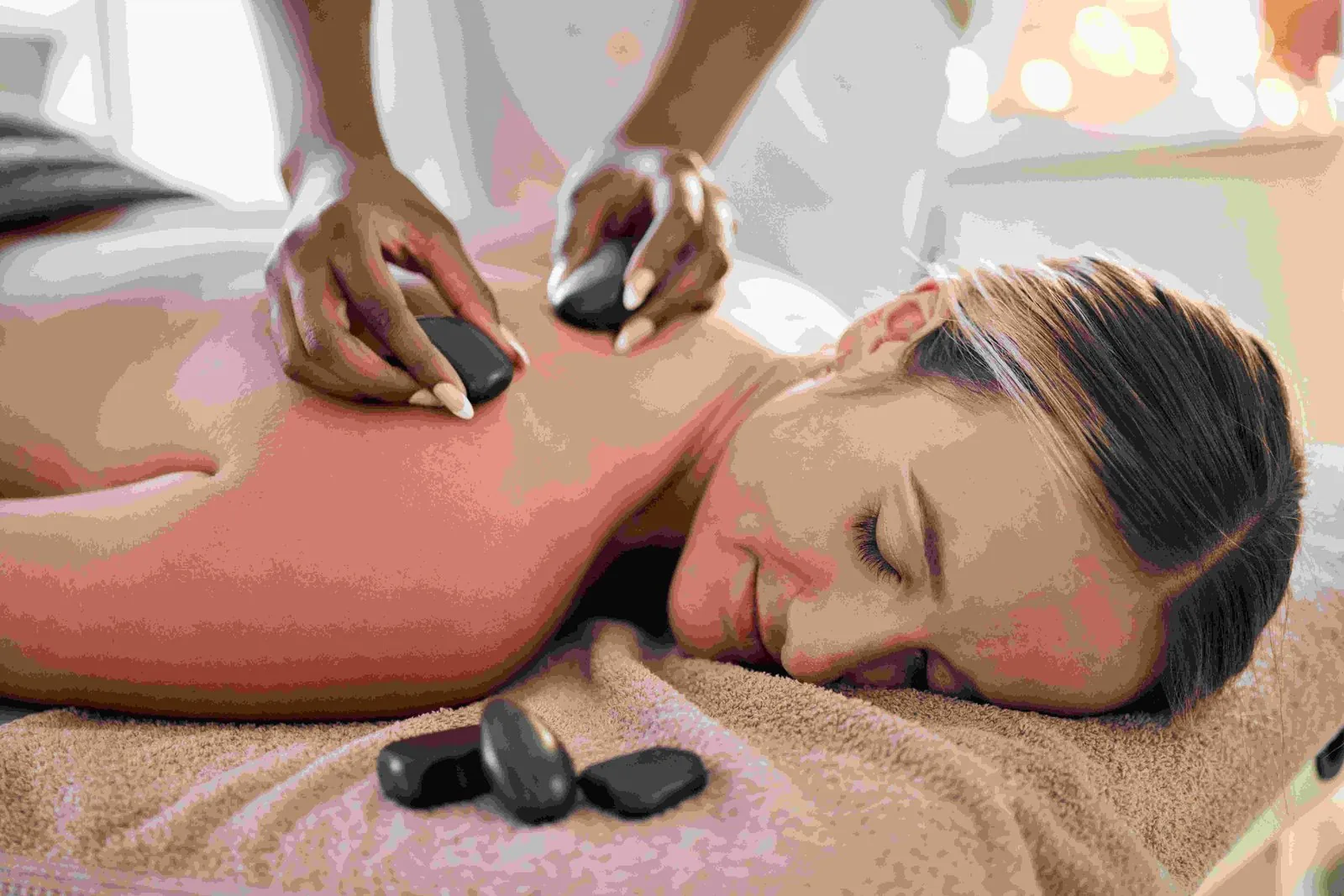 Hot stone massage with smooth heated stones on a woman's back