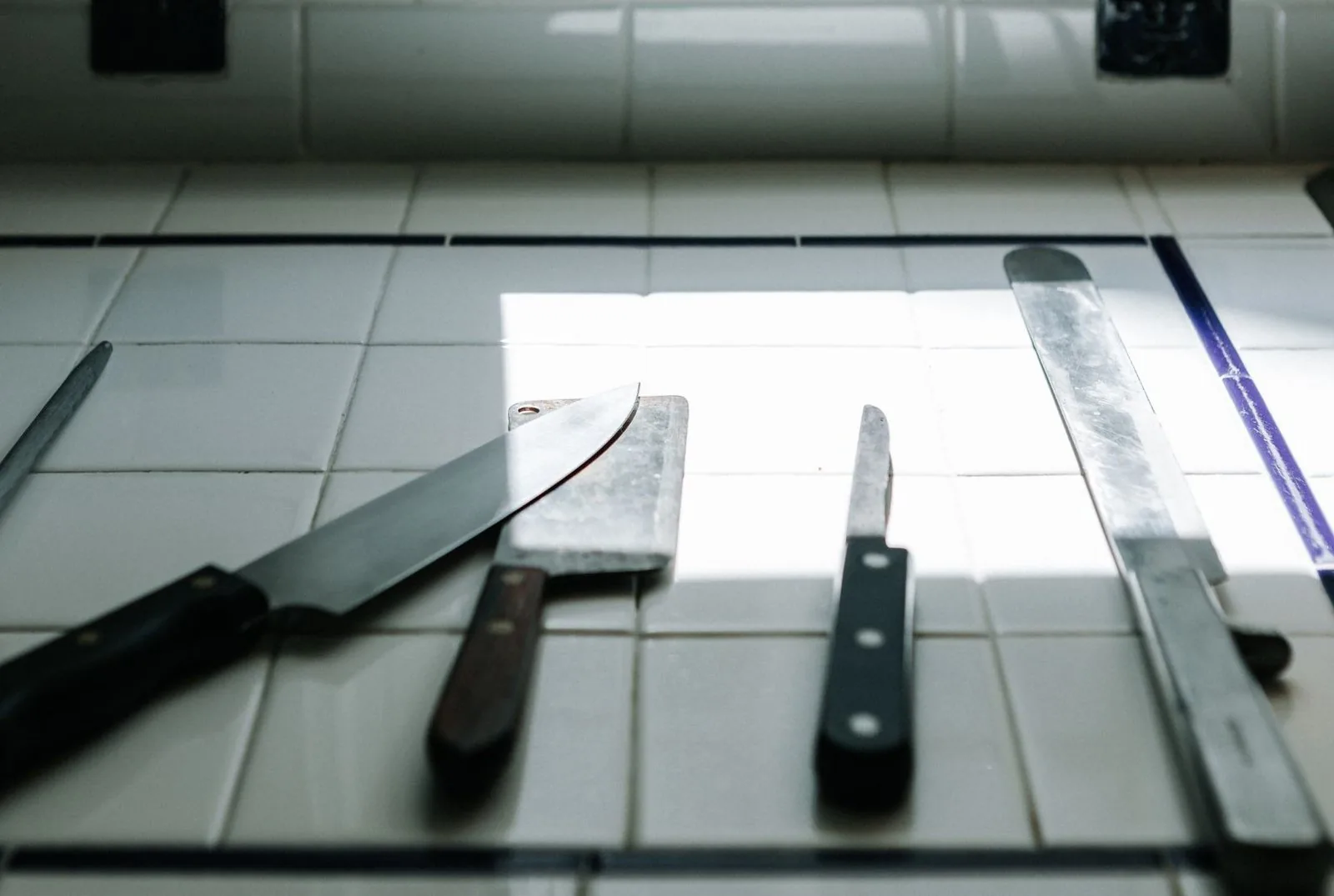 Hands properly cleaning a kitchen knife with a sponge