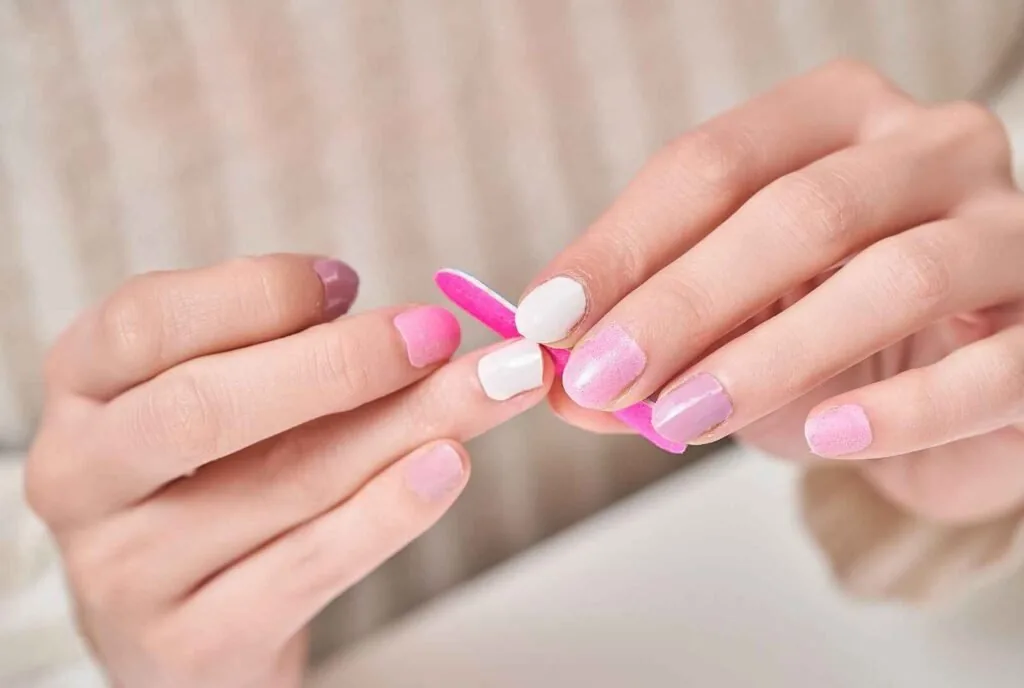Nail technician applying acrylic during a salon appointment